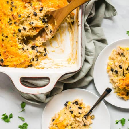 enchilada casserole with chicken and spaghetti squash plated beside the casserole dish