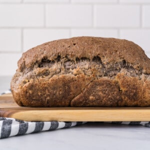 a side view of vegan sourdough bread on a wooden cutting board