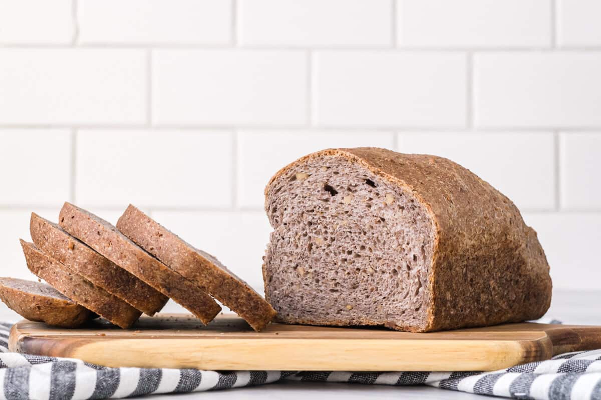 half a loaf of vegan sourdough bread with slices to the side