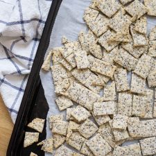 Baking sheet filled with homemade sourdough crackers with flax and chia seeds