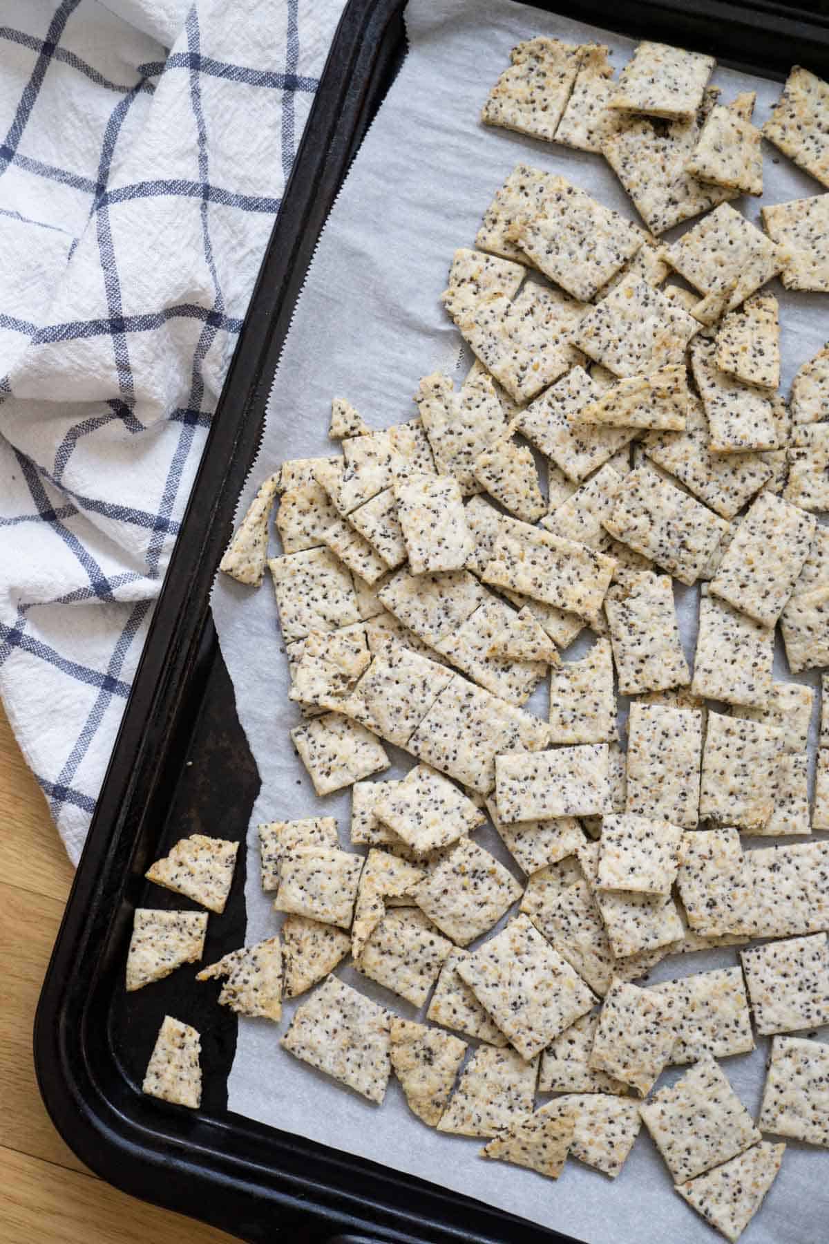 Baking sheet filled with homemade sourdough crackers with flax and chia seeds