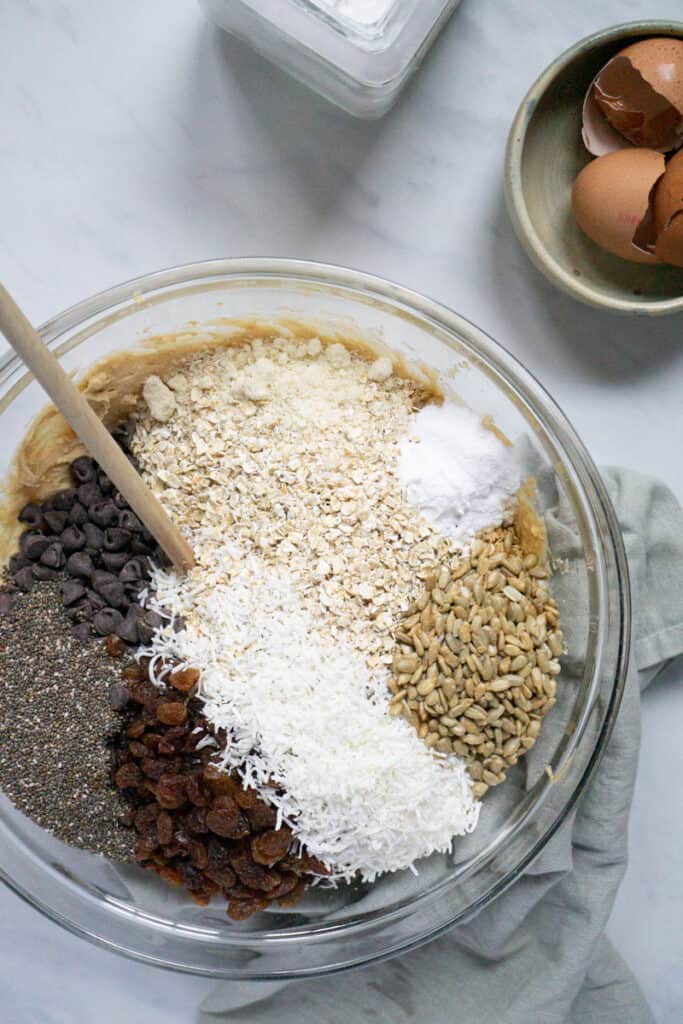 Ingredient for trailmix cookies in a mixing bowl.