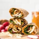 a side view of halloumi wraps with spinach, radishes, and romesco sauce