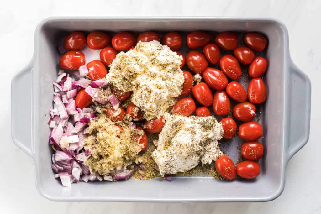 All the ingredients for the sauce for the creamy roasted tomato farfalle in a baking dish.