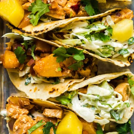 Closeup image of chicken pineapple tacos on a sheet pan