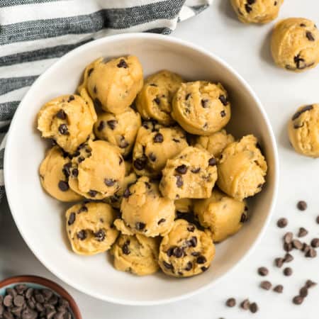an overhead view of a bowl of edible chocolate chip cookie dough balls