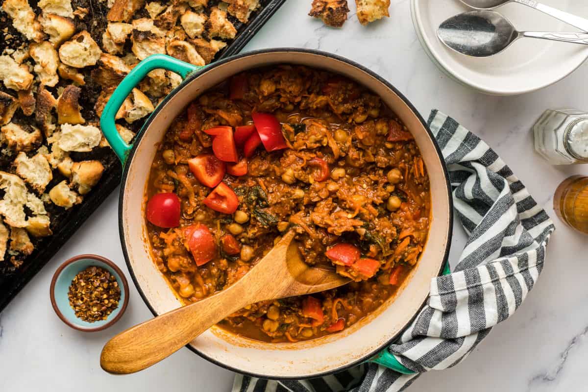 A pot of chorizo chickpea stew with a pan of ciabatta croutons.